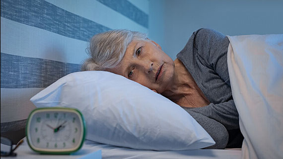 Worried senior woman in bed at night suffering from insomnia