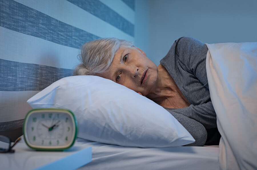 Worried senior woman in bed at night suffering from insomnia