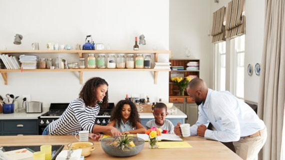 Young black family busy together in their kitchen