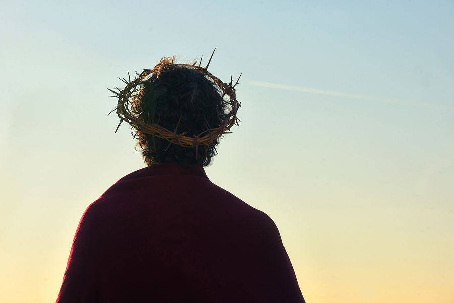 Jesus Christ with crown of thorns against the sun