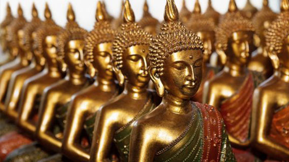 Gold Buddha statues sitting in row