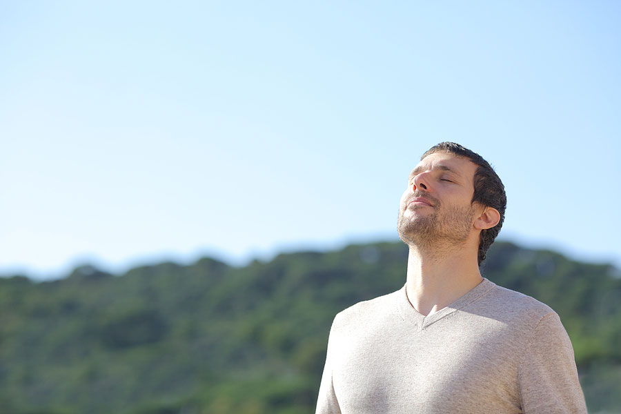 Relaxed Man Breathing Fresh Air Near The Mountains With A Blue S