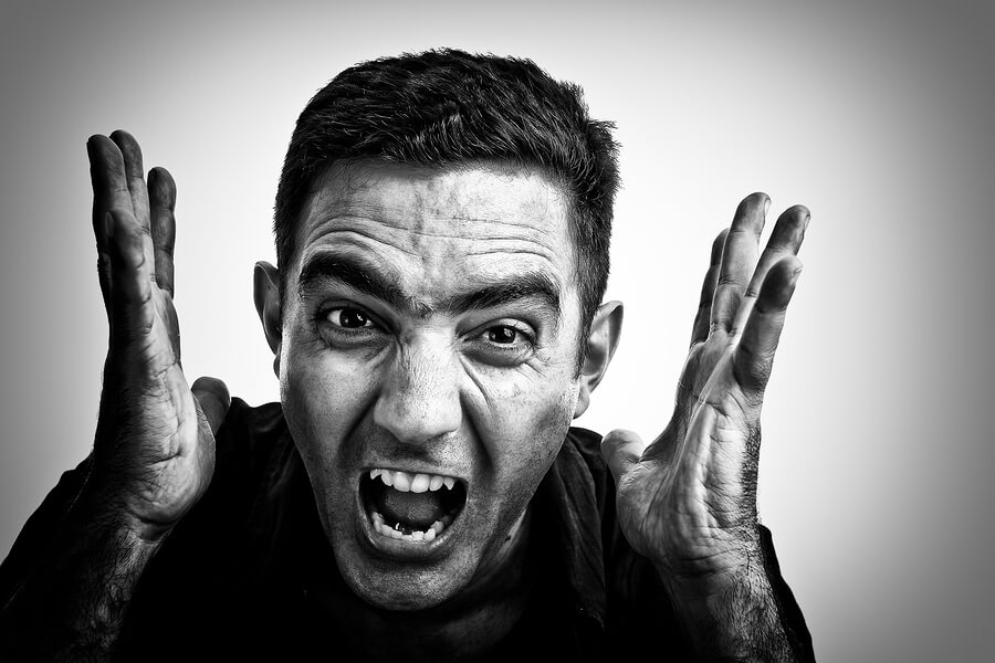 Black and white image of a man yelling with a violent face
