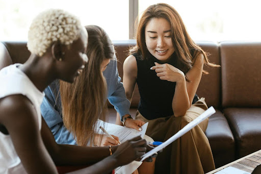  A teenage girl and her mother meet with a mentor to discuss job-searching programs.